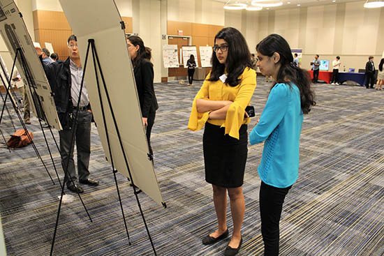 Soper group members Kavya Dathathreya and Harshani Wijerathne take in the poster session.