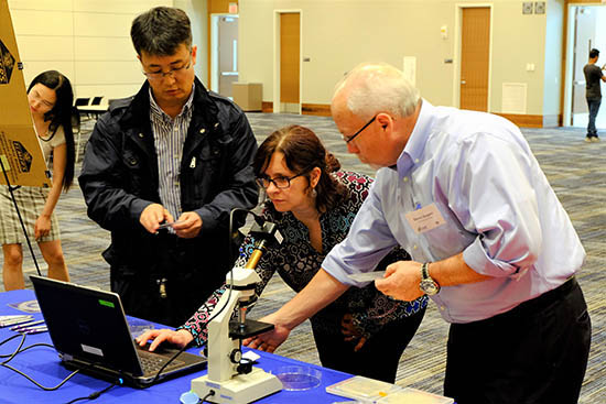Daniel Park, Maggie Witek, and Steven Soper examine microfluidic devices under a microscope.