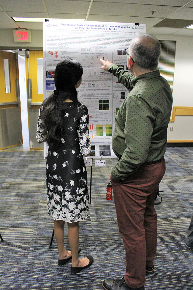 EAB member Dr. Rich Superfine (right) understands a figure in graduate student Harshani Wijerathne's poster