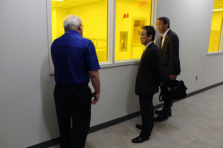Dr. Ueda and Mr. Kaito listen to Dr. Soper talk about the clean room