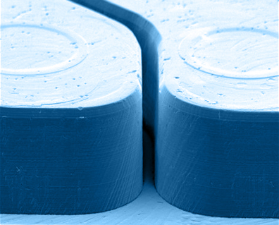 A close-up of two cylindrical objects with textured tops, tinted in shades of blue.