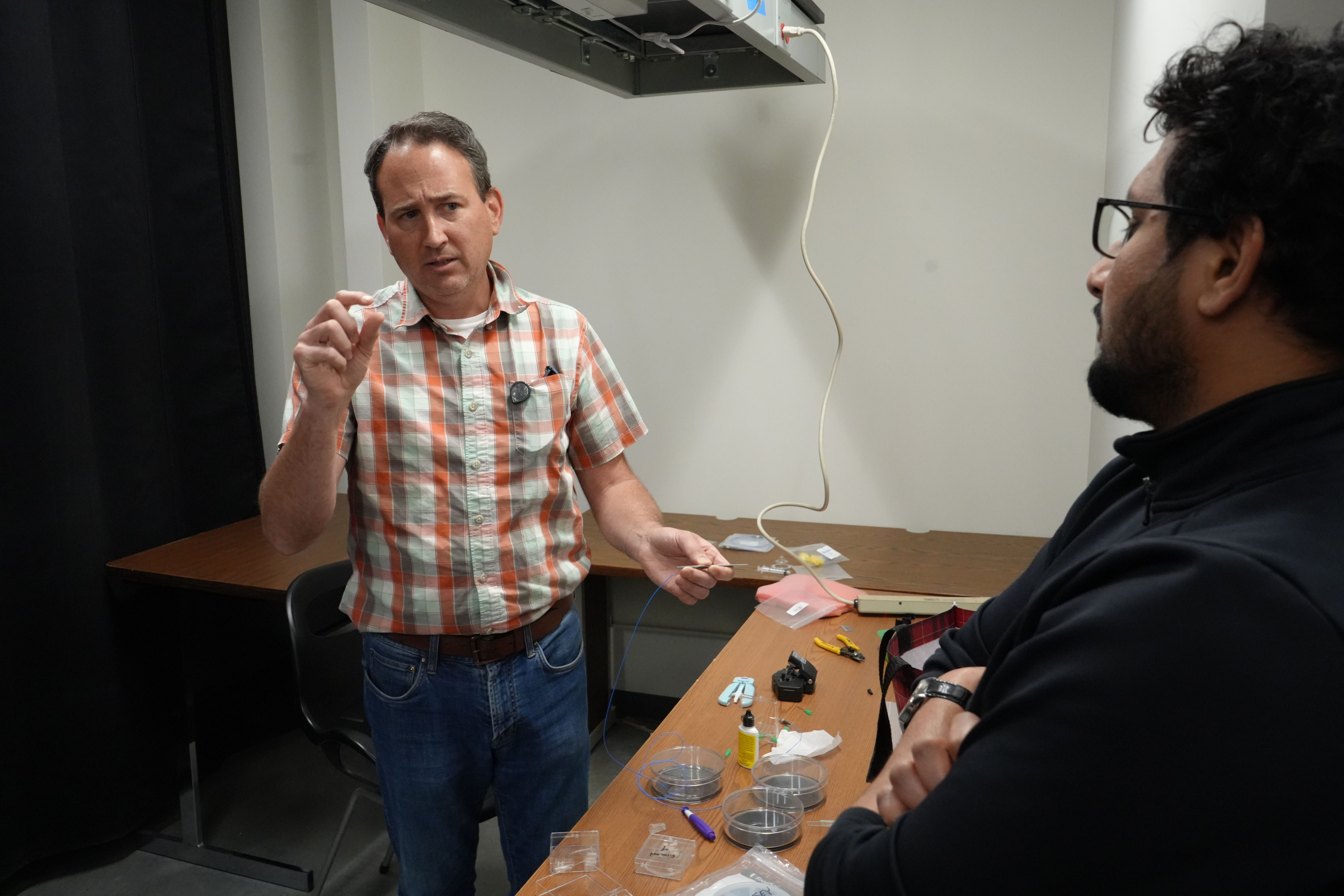 Dr. Greg Cooksey gestures while talking to researcher Suresh Patabendi